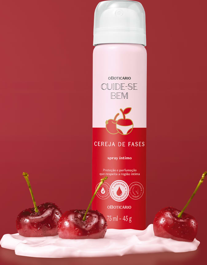 Imagem de frasco de spray íntimo desodorante da marca Cuide-se Bem Cereja De Fases. A embalagem é rosa e vermelha e está em um cenário de fundo vermelho com um creme branco na superfície e cerejas vermelhas frescas espalhadas sobre ele.