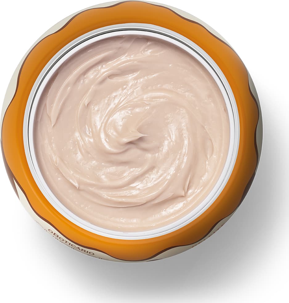 A imagem mostra o recipiente de plástico laranja aberto e contendo um creme branco cremoso e brilhante com textura suave e homogênea.
