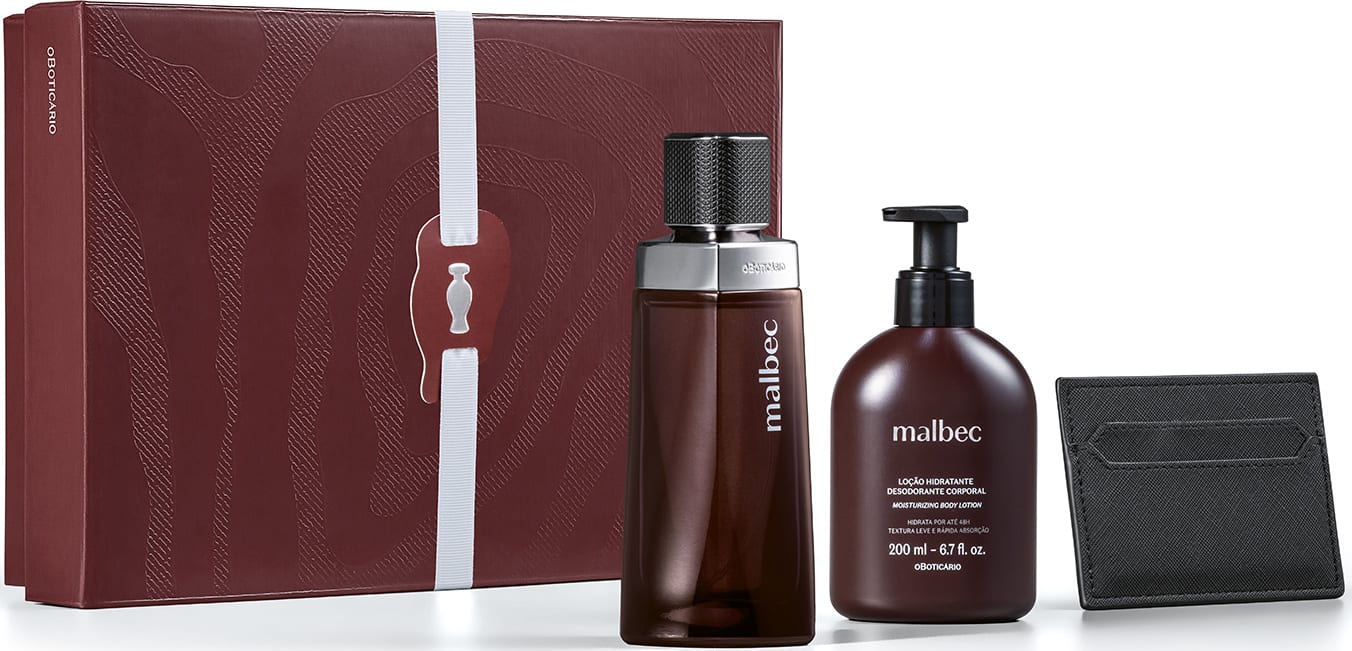 Caixa de presente marrom com padrão de raíz de árvore, contendo frasco de item de perfumaria Malbec de 200 ml e bisnaga de 200 ml da mesma marca, acompanhados de uma carteira preta.