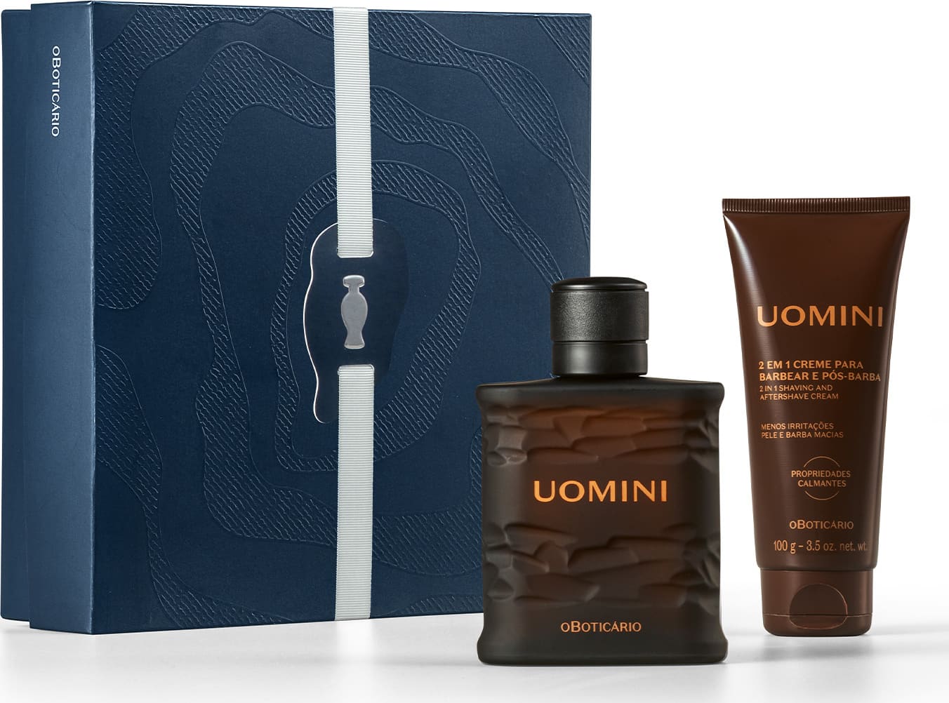 Caixa azul-marinho com padrão ondulado, contendo frasco de item de perfumaria da marca Uomini e tubo de creme pós-barba da mesma marca, em embalagens com cores predominantes preta e marrom.
