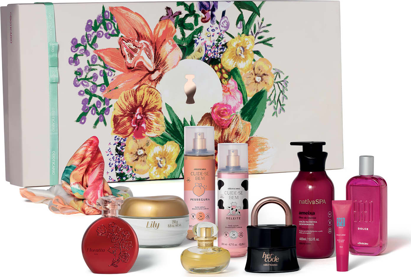 A imagem mostra um kit de presentes contendo uma caixa branca com ilustrações florais, seguida de diversos produtos de perfumaria e cuidados pessoais do Boticário, incluindo frascos, potes e bisnagas em cores variadas.
