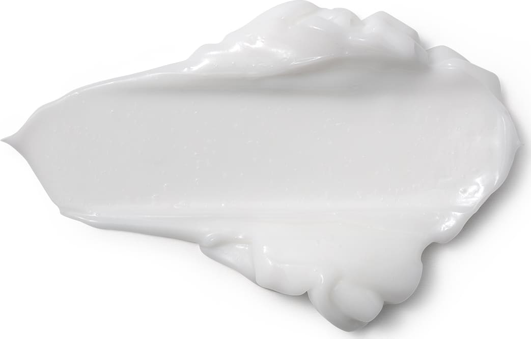 Textura branca e cremosa de produto de corpo e banho, com aspecto liso e brilhante, espalhada sobre superficie clara, ocupando grande parte da imagem.