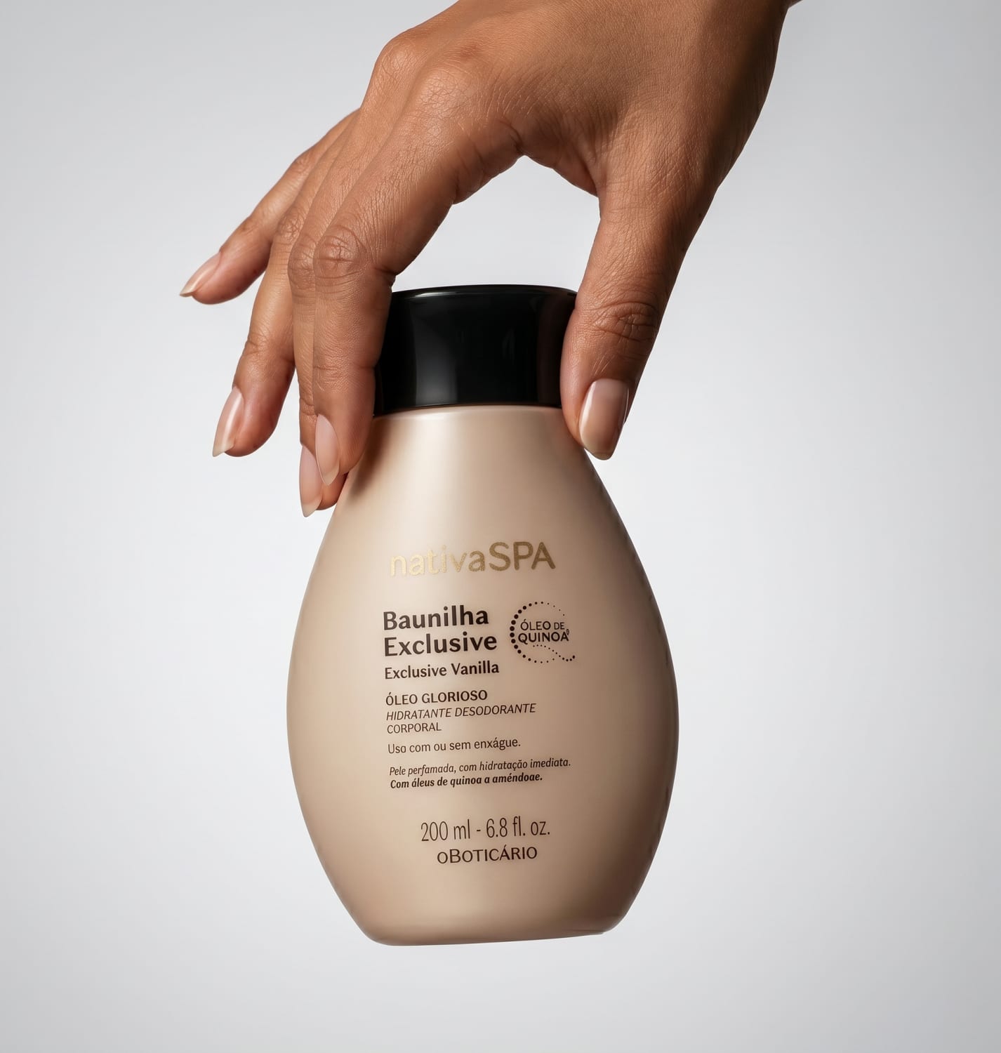 Embalagem de item de cuidados para corpo e banho da marca Nativa SPA Baunilha Exclusive sendo seguro por mão feminina de pele branca em fundo cinza claro.