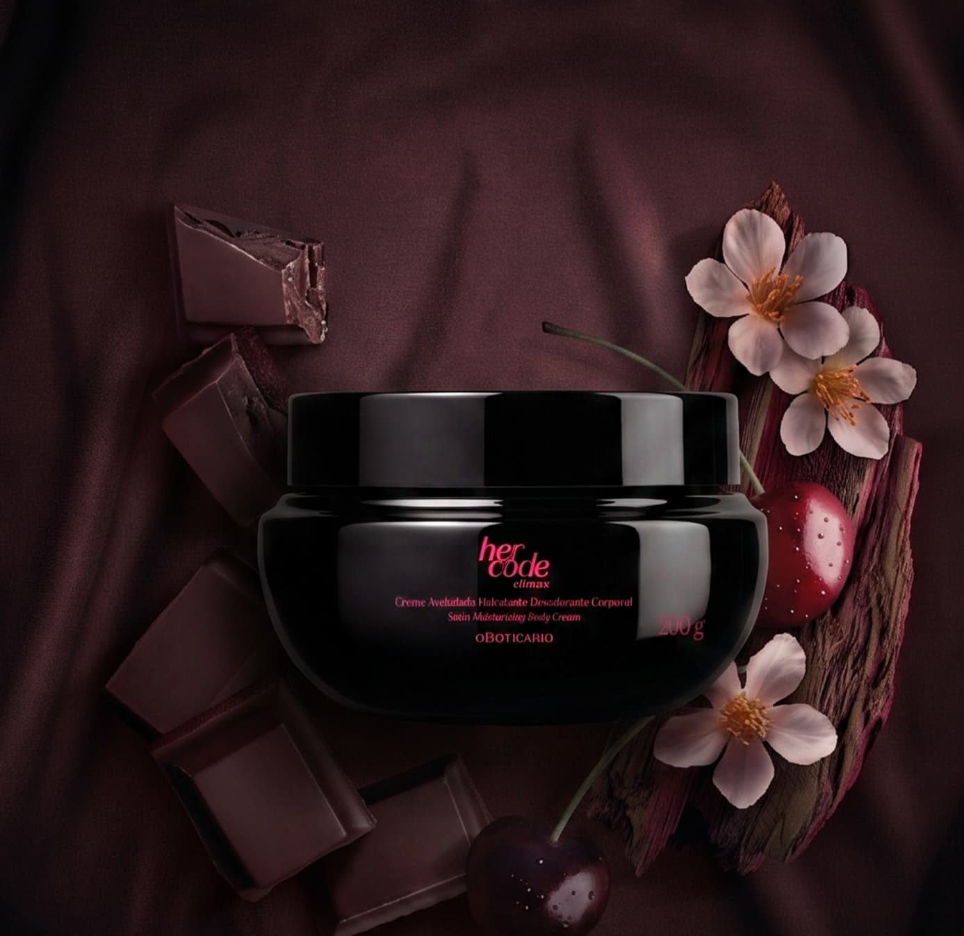 Pote preto de creme corporal da marca Her Code sobre superfície escura, com flores brancas e pedaços de chocolate ao redor, em ambiente monocromático de tons de vinho e marrom.