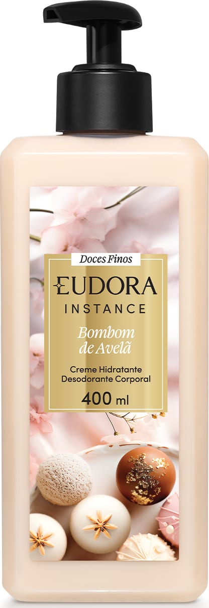Embalagem plástica transparente com imagem de bombom de açúcar na cor bege, nozes, especiarias e flores decorativas no rótulo. Retângulo dourado com o nome Eudora Instance Bombom de Avelã 400ml em letras pretas e brancas. Bomba dosadora preta como tampa.