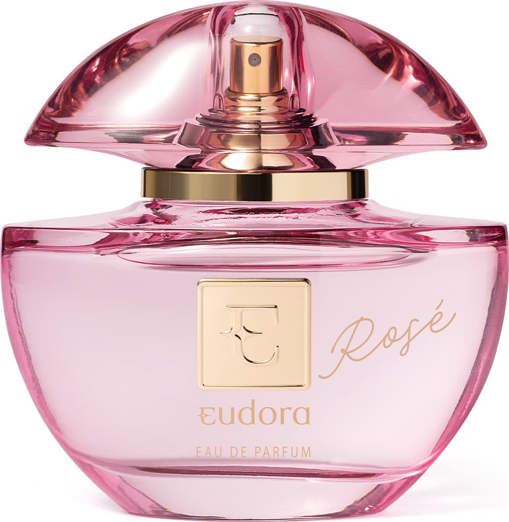 Frasco do Eau de Parfum Eudora Rosé. O frasco é feito de vidro rosa com detalhes em dourado. Na parte frontal, está gravado o nome "Rosé" em letras douradas cursivas. O topo do frasco tem uma tampa em vidro que deixa entrever a parte dourada do borrifador