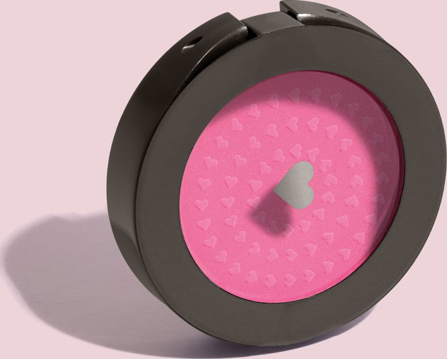 Estojo compacto redondo na cor preta com tampa transparente com coração ilustrado contendo 2g de blush em pó compacto Rubor Rosa Rosandilex da marca Quem Disse, Berenice? em fundo lilás.