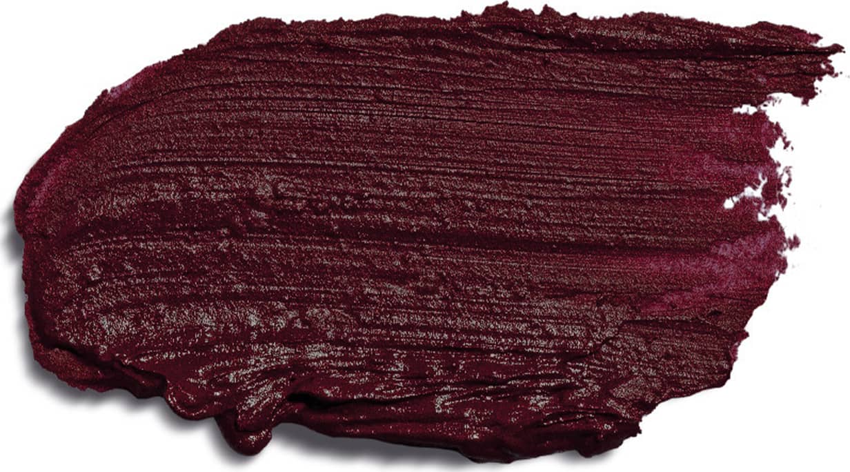 Textura cremosa e densa de tom roxo escuro espalhada sobre superfície branca, ocupando boa parte da imagem.