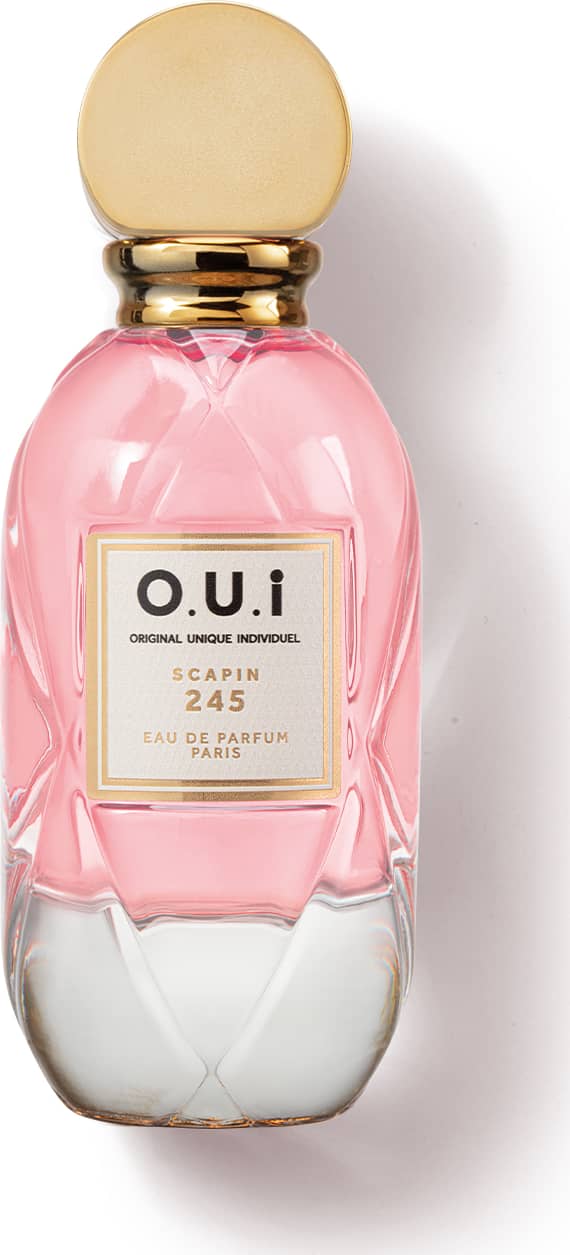 Frasco de perfume O.U.i. com design elegante e cores rosa e dourado. Rótulo com nome da marca e informações sobre a fragrância "Scapin 245". Embalagem de vidro com tampa dourada, apresentando uma aparência sofisticada e exclusiva.