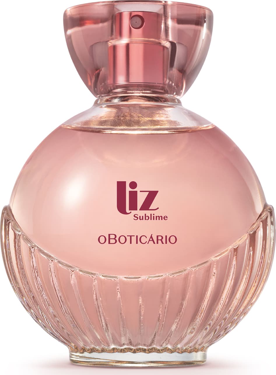 frasco de item de perfumaria da marca Liz Sublime, com embalagem de vidro arredondada rosa-claro facetado e nome da marca em vermelho escuro gravado no vidro. A tampa é em acrílico transparente e permite ver a tampa borrifadora de tom metálico rosa.