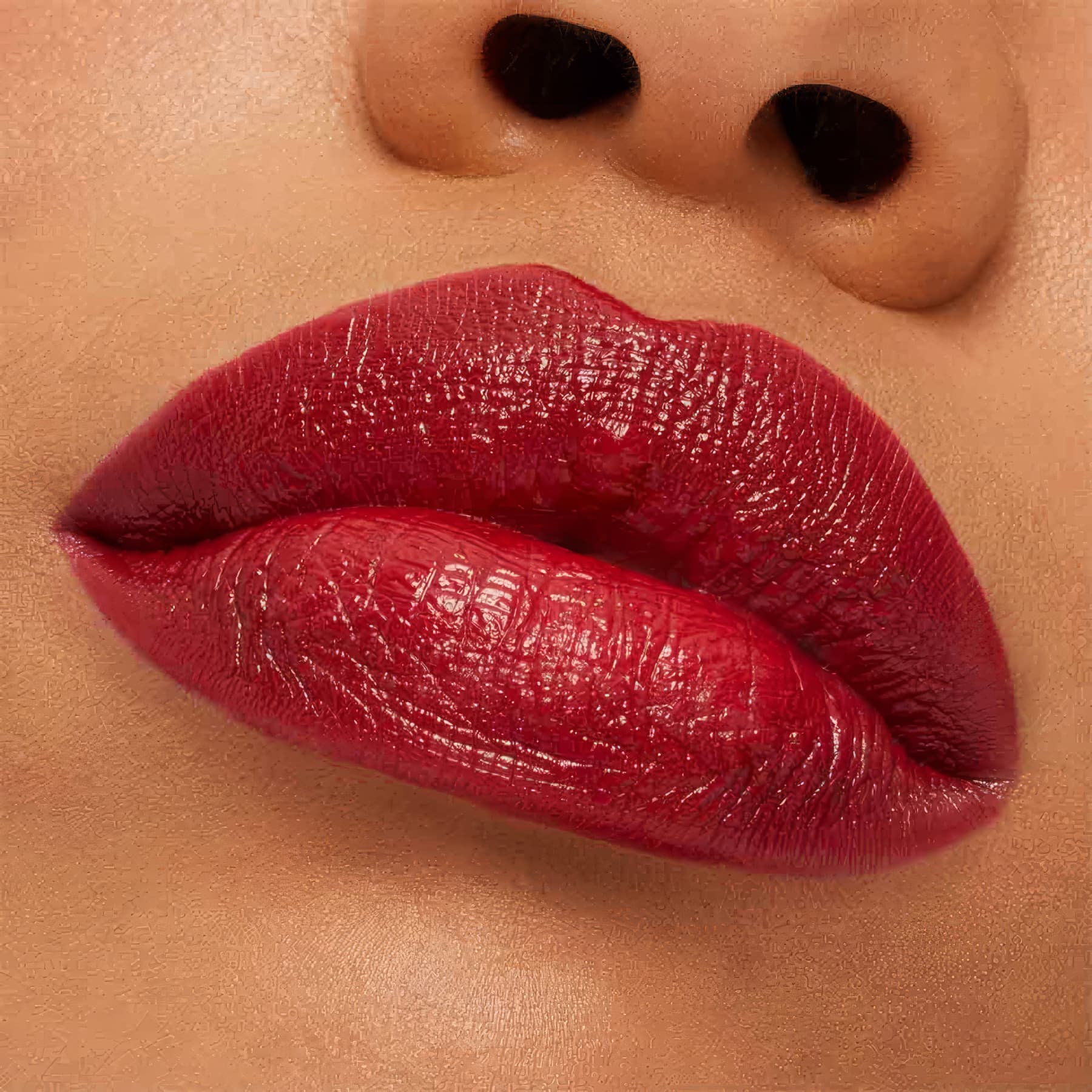 A imagem mostra a boca de uma mulher usando o batom.