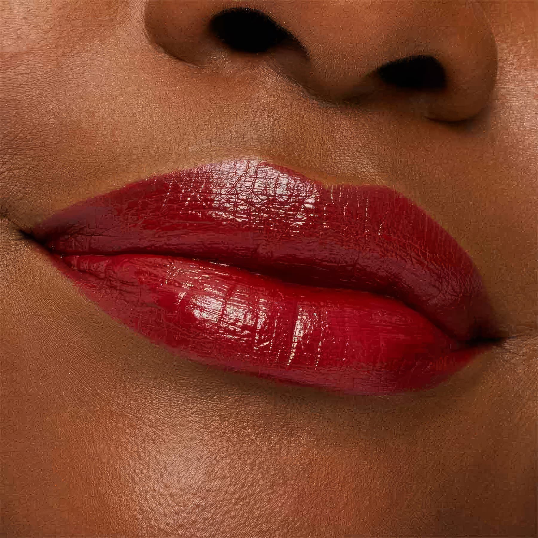 A imagem mostra a boca de uma mulher usando o batom.