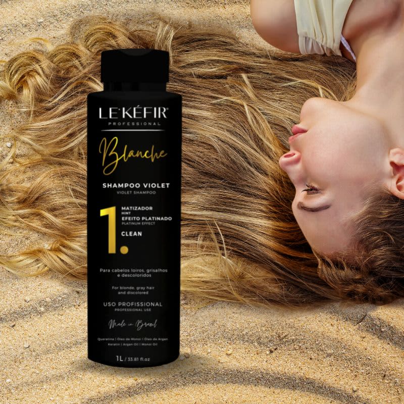 A imagem mostra o frasco do shampoo posicionado junto a longos cabelos loiros espalhados, pertencentes a uma pessoa que não é totalmente visível na foto.