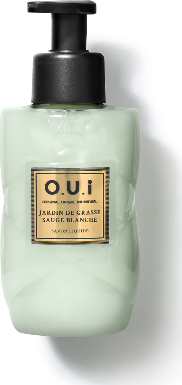 Frasco tipo pump de sabonete líquido da marca O.U.i. com rótulo em fundo verde-claro e detalhes dourados, contendo a descrição "Jardin de Grasse Sauge Blanche" (Jardim de Grama Branca).