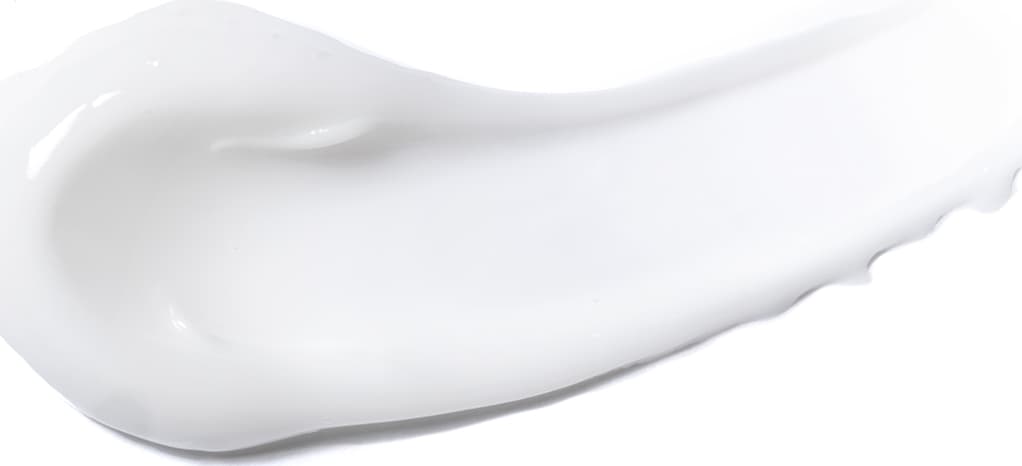 Textura cremosa e suave, com aspecto leitoso e brilhante. Apresenta consistência densa e uniforme, sem irregularidades visíveis. Cor predominantemente branca, aparência delicada e refinada.