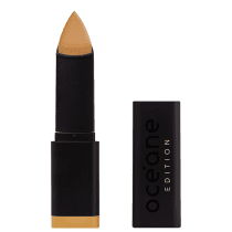 A imagem mostra a Base em Bastão Océane Edition Foundation Stick: embalagem retangular preta com o logotipo "Océane Edition" impresso em relevo na parte frontal. A base tem formato triangular.