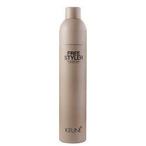 A imagem mostra o spray fixador Keune Free Styler em embalagem cilíndrica de cor bege claro. No frasco está impresso em letras pretas "FREE STYLER 360° freestyling hairspray Laque 360° freestyle". Na parte inferior está escrito "KEUNE" em letras pretas.
