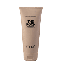 A imagem mostra o Gel de Cabelo The Rock da marca Keune. O produto vem em um tubo plástico na cor bege claro. Na parte superior está impresso em letras pretas "THE ROCK Strong high-shine gel".