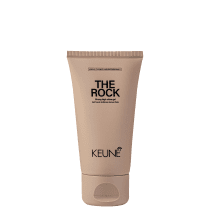 A imagem mostra o Gel de Cabelo The Rock da marca Keune. O produto vem em um tubo plástico na cor bege claro. Na parte superior está impresso em letras pretas "THE ROCK Strong high-shine gel".