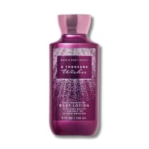 Frasco de loção corporal da Bath & Body Works com 236 ml, na cor roxa metálica com detalhes em rosa, com rótulo destacando "A Thousand Wishes" e informações sobre os ingredientes.