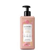 Embalagem plástica de 400ml com bomba dosadora preta. A embalagem é rosa claro com ilustrações florais em tons de rosa e amarelo. O rótulo indica que é da linha "Cereja e Amendoas" e contém 97% de ingredientes naturais.