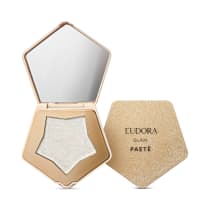 O produto apresentado é um item de maquiagem da marca Eudora, da linha Glam. Trata-se de um Iluminador com espelho, em formato pentagonal, com uma estrutura dourada. Dentro, há um pó iluminador prateado e espelho na parte interna da tampa.