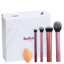 A imagem mostra uma caixa branca presenteável da marca Beleza na Web e quatro pincéis de diferentes tamanhos e uma esponja de maquiagem da Real Techniques.