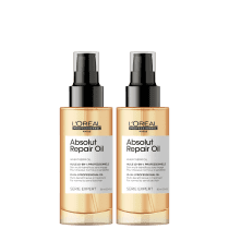Dois frascos de óleo reparador Absolut Repair Oil da linha Serie Expert da L'Oréal Professionnel. Os frascos são de plástico transparente com tampa preta fosca. O rótulo indica que é um óleo de gérmen de trigo 10 em 1. O volume é de 90 ml