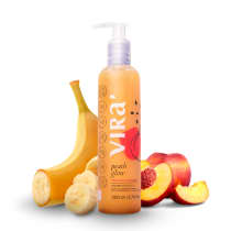 Frasco de shampoo da marca Virá Cosméticos, com rótulo laranja e texto "Peach Glow", contendo 200 ml. Ao lado, bananas e pêssegos, sugerindo os ingredientes naturais do produto.