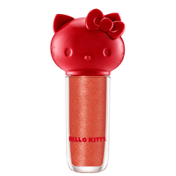 Maquiagem em formato cilíndrico com a cabeça da personagem Hello Kitty como tampa. A parte superior é vermelha com detalhes em relevo que representam os olhos, orelhas e laço da Hello Kitty. É possível ver a cor do produto pelo corpo transparente.