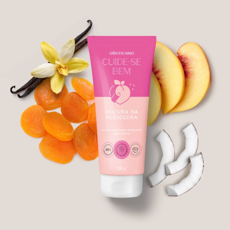 O produto apresentado é uma embalagem, um tubo rosa com o nome do produto "Doçura na Pessegura" e informações sobre seus benefícios. Ao redor do produto, há frutas e flores, como  pêssegos e uma flor de baunilha.
