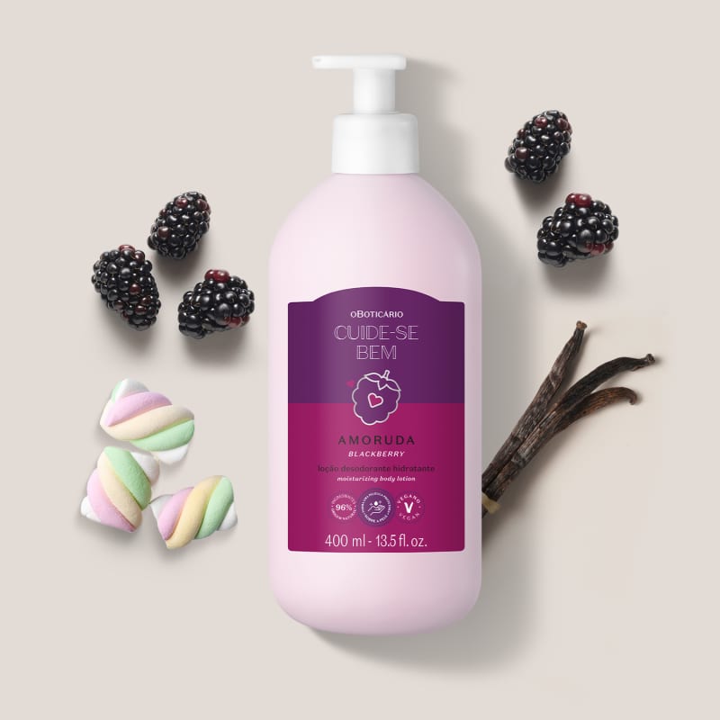 Ambiente de beleza com produto da marca Cuide-se Bem, embalagem rosa e roxa com aroma de amora, rodeado por marshmallows coloridos e frutas frescas, sugerindo um cenário de cuidados corporais e bem-estar.