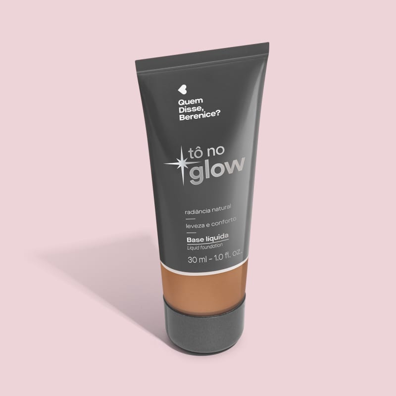 O produto apresentado é uma base líquida da marca Tô no Glow, com embalagem em tubo plástico preto e branco. O rótulo exibe o nome da marca e a descrição "Radiância natural, leveza e conforto". O produto é classificado como "Base líquida".