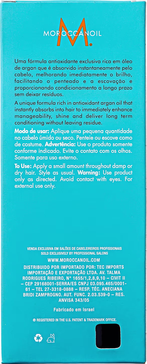 Parte de trás da caixa do Óleo Capilar Moroccanoil Treatment, embalagem retangular de cor turquesa. Traz a descrição do produto, instruções de uso e advertências. Fórmula à base de óleo de argan que promete brilho, maciez e condicionamento para os cabelos