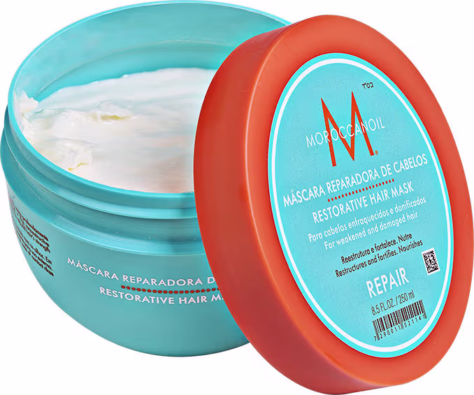 A imagem mostra a Máscara Capilar Moroccanoil Repair 250ml, um pote redondo de plástico na cor azul turquesa com detalhes em laranja. As informações sobre o produto estão escritas em inglês e espanhol no rótulo do pote.