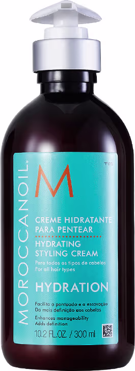 A imagem apresenta o Creme para Pentear Moroccanoil Hydration Styling 300ml, embalagem marrom com bomba dosadora branca na parte superior. Traz rótulo azul turquesa com o logotipo "M" laranja e texto com foco na funcionalidade do produto.