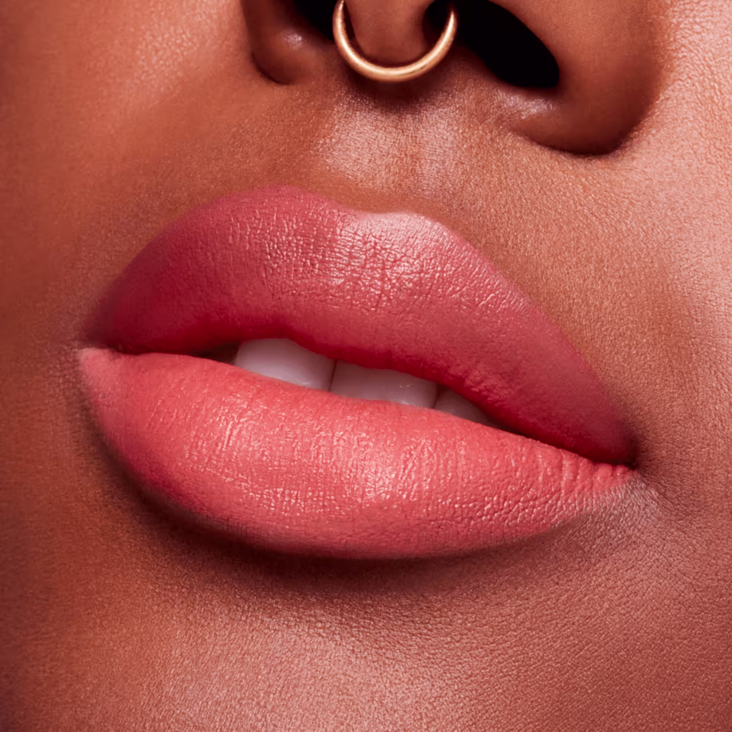 A imagem mostra a boca de uma mulher usando o batom.