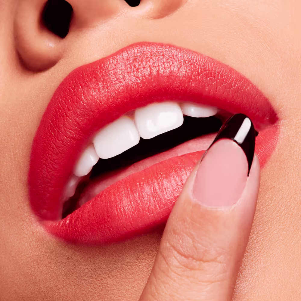 A imagem mostra a boca de uma mulher usando o batom.