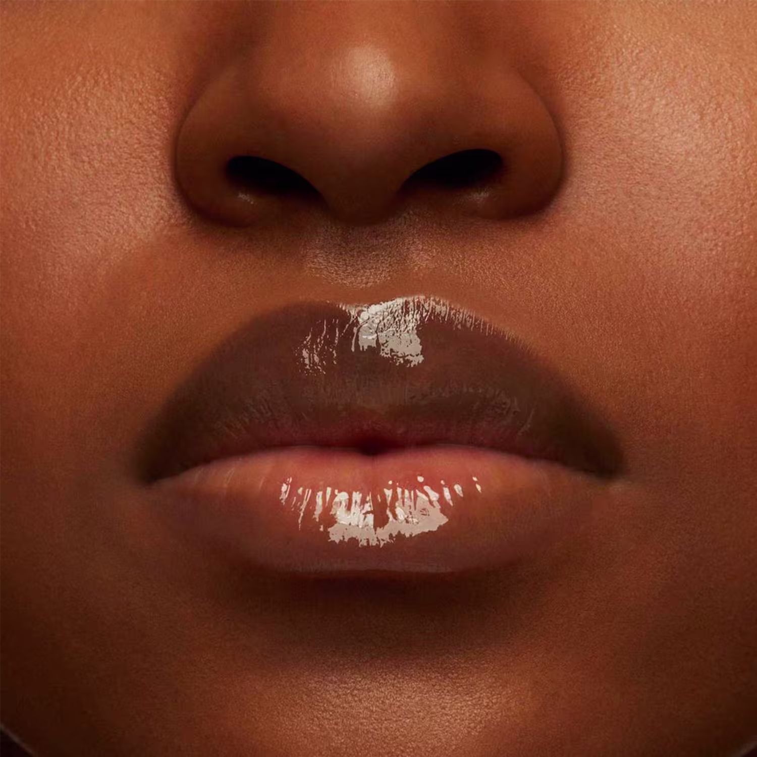 A imagem mostra a boca de uma mulher usando o balm.
