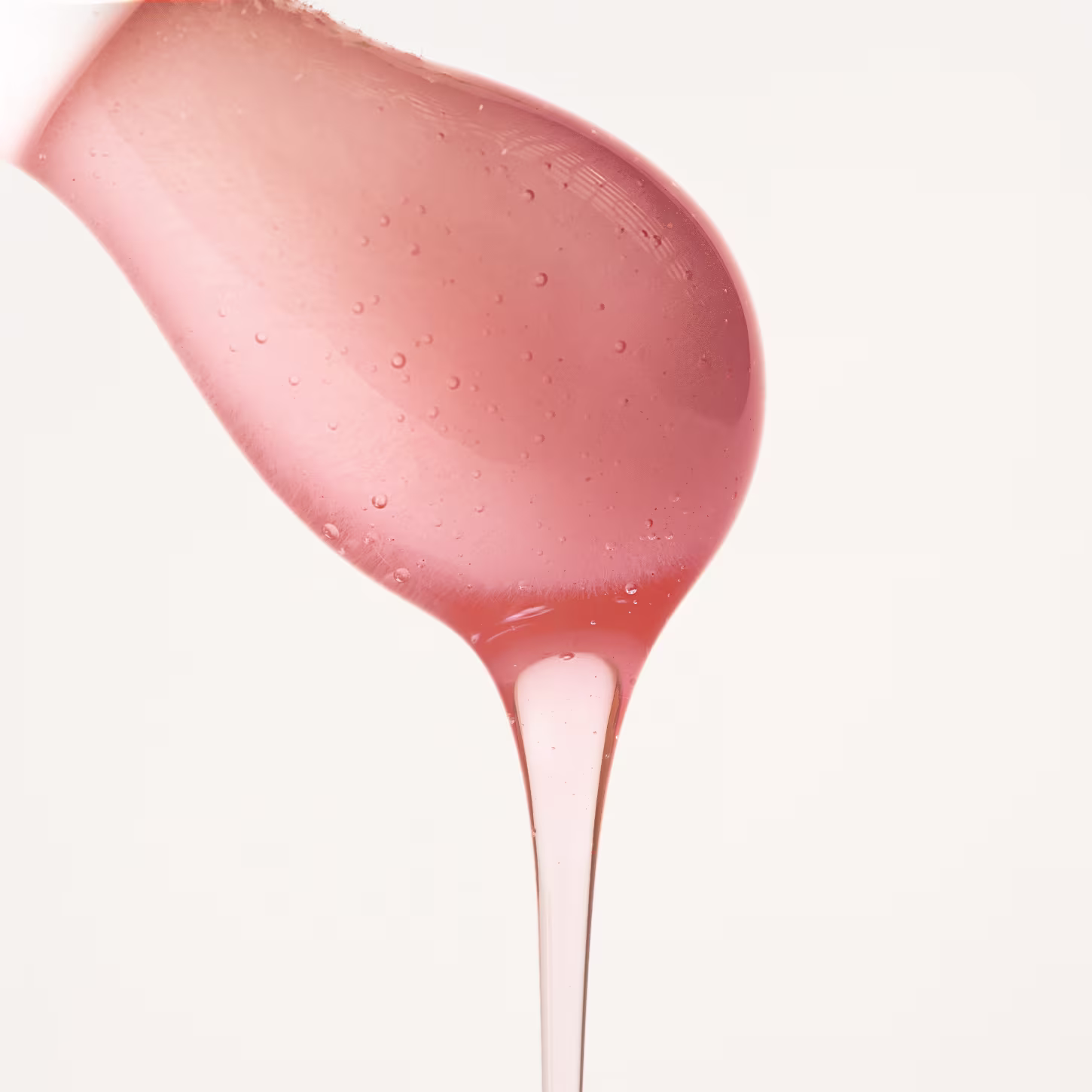 A imagem mostra o aplicador do produto com o lip oil escorrendo na ponta.