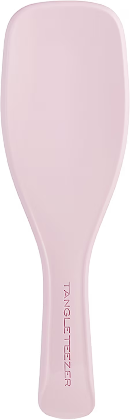 Escova de cabelo Tangle Teezer. Corpo alongado e arredondado na extremidade, feito de plástico rígido na cor rosa claro. O nome da marca "Tangle Teezer" está impresso em letras maiúsculas ao longo do cabo da escova. Design ergonômico e compacto.