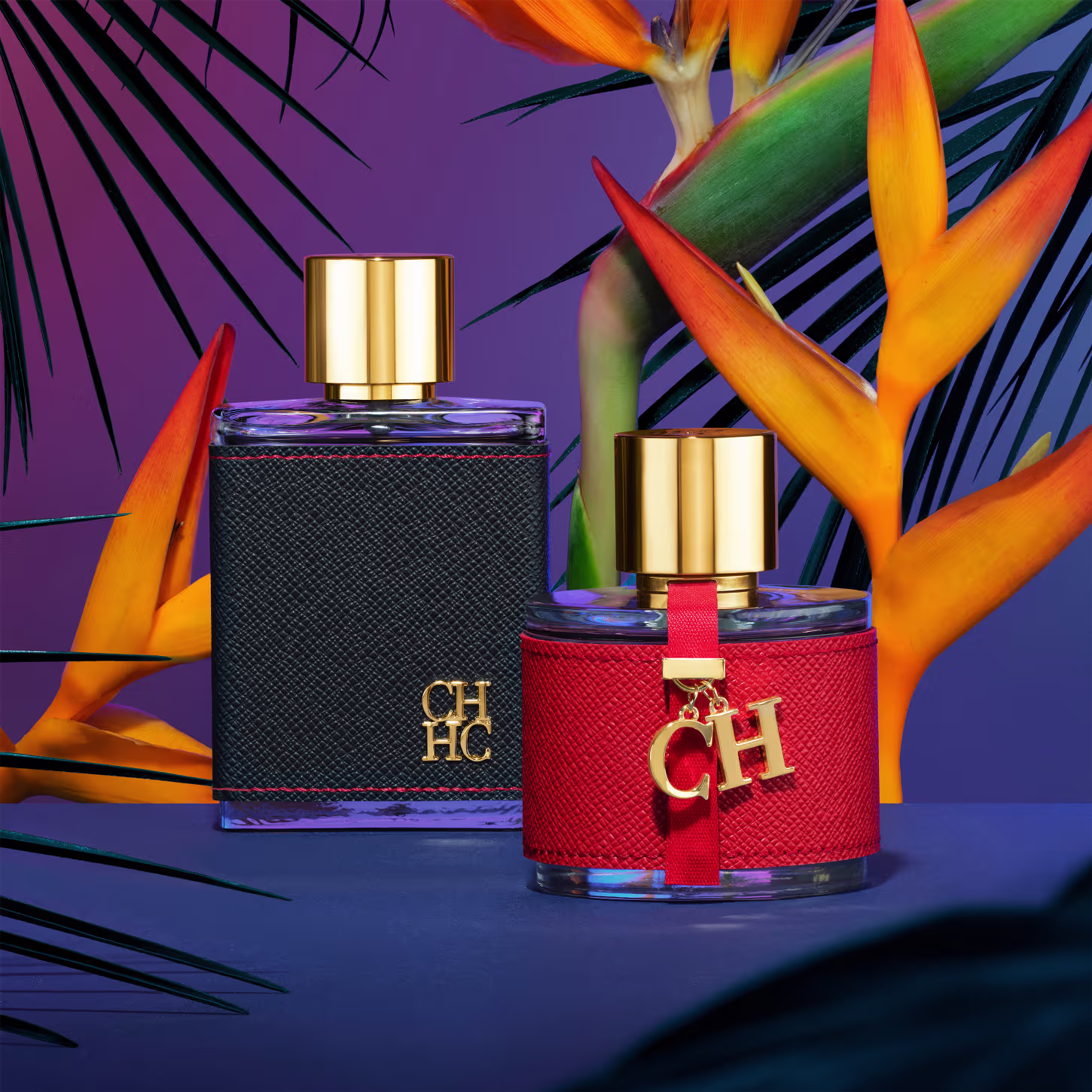 A imagem mostra dois frascos de perfumes, da mesma coleção. Um maior, retangular, com capa preta e tampa dourada, e um menor, arredondado, com capa vermelha e tampa dourada. Ambos apresentam a logo da marca em alto relevo.