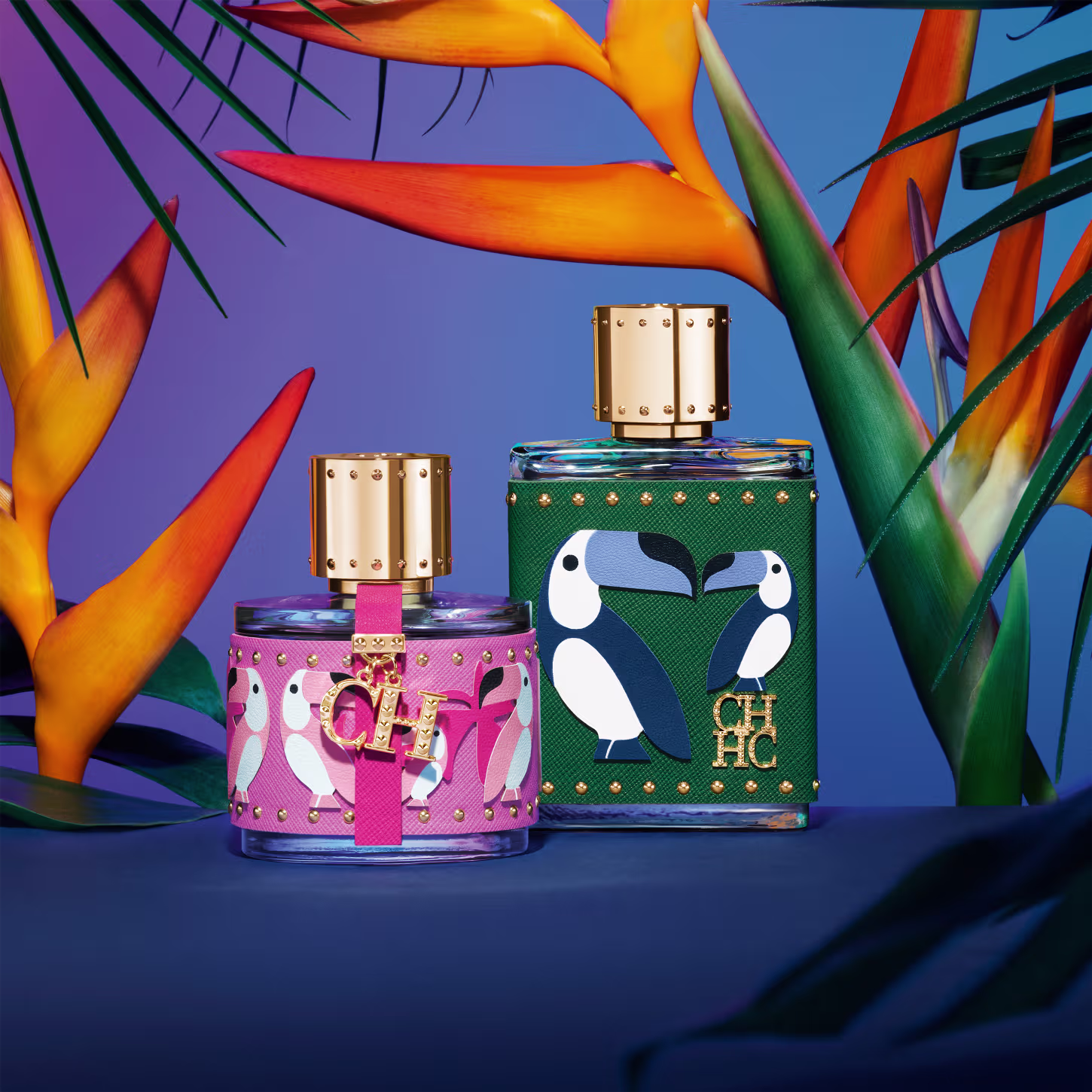 A imagem mostra dois frascos de perfume da marca Carolina Herrera, do lado esquerdo, um frasco pequeno, arredondado, com capa rosa com estampas de pássaros rosa e detalhes dourados. Do lado direito, o frasco de CH Men Birds of Paradise.