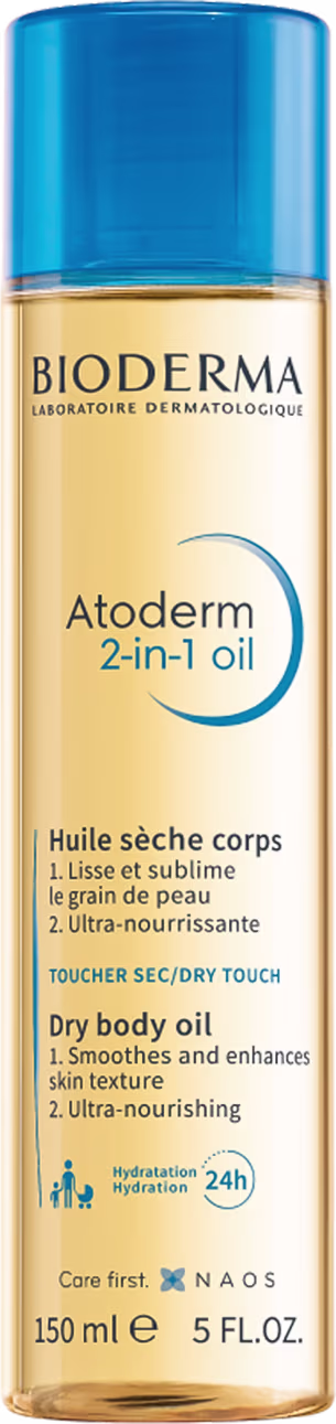 A imagem mostra o óleo corporal de Bioderma Atoderm 2-in-1 Oil. Possui um frasco plástico transparente que permite ver a cor dourada do óleo e uma tampa azul clara. Na parte frontal apresenta informações sobre o óleo em inglês.
