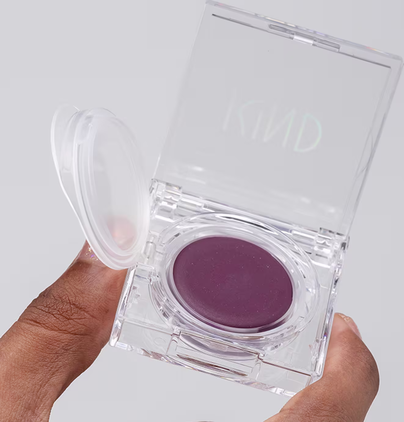 A imagem mostra uma mão negra segurando a embalagem do blush aberta.