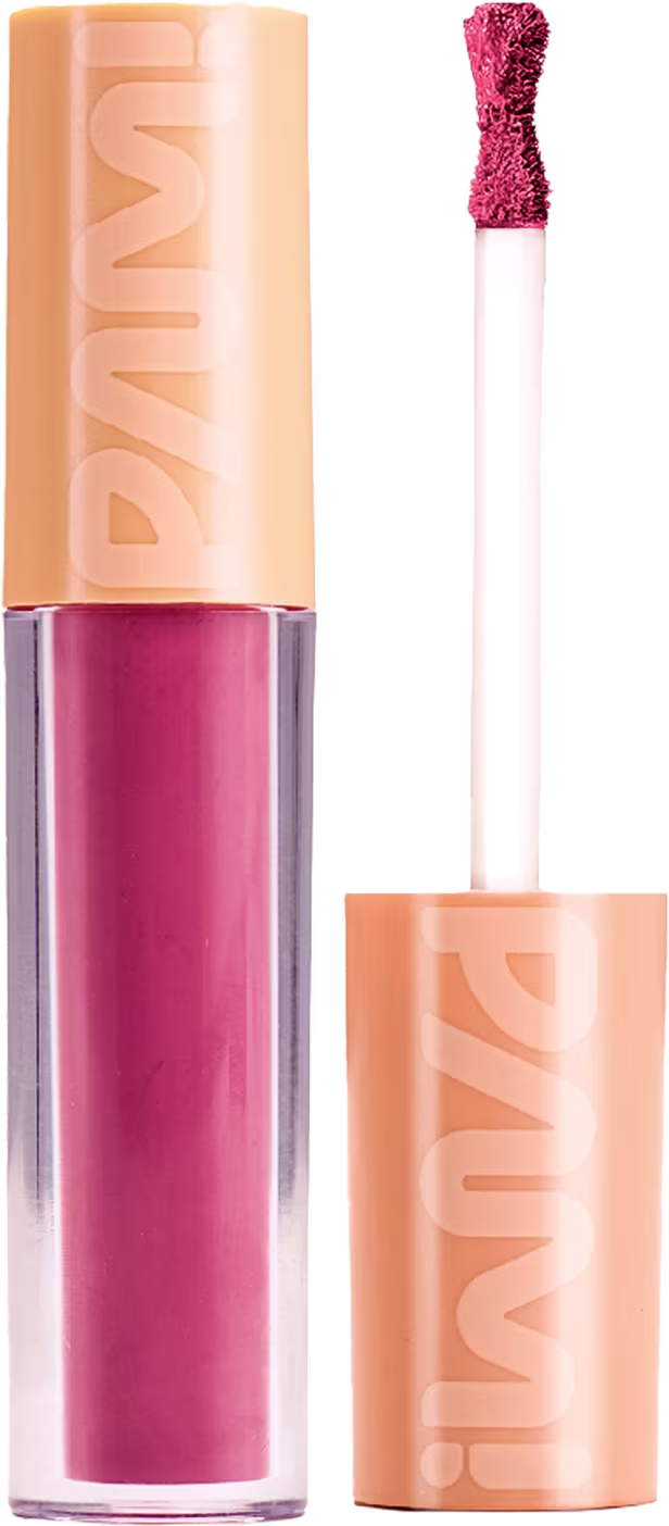 A imagem mostra o batom líquido matte de Pam by Pamella. Seu tubinho é transparente e mostra a cor rosa do batom. Ao lado tem a tampa laranja com a logo PAM! escrita e o bastão com uma ponta de aplicador em formato de ampulheta.