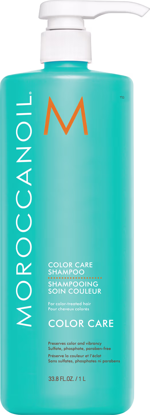 A imagem mostra o Shampoo Color Care 1L da marca Moroccanoil. Embalagem plástica na cor azul turquesa, com letras brancas e pretas e logotipo da marca em laranja. O frasco tem uma bomba dosadora branca na parte superior.