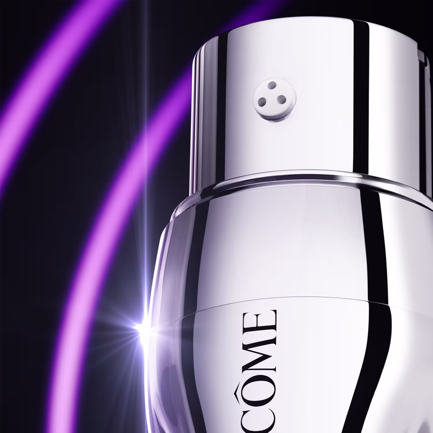 Sérum em frasco cilíndrico branco e cromado. Tem tampa arredondada com três pequenos círculos. Na parte inferior, está impresso o logotipo "CÔNE", pedaço do nome da marca Lancôme. O frasco está posicionado contra um fundo preto, com um feixe de luz roxa.