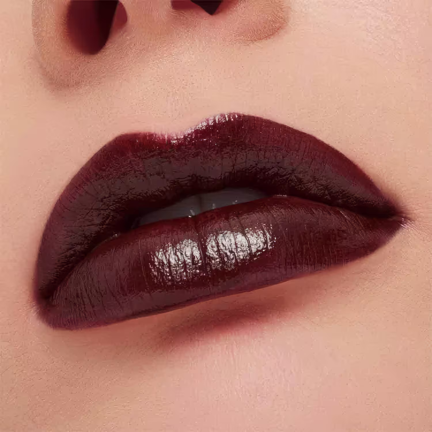 A imagem mostra a boca de uma mulher usando o batom.