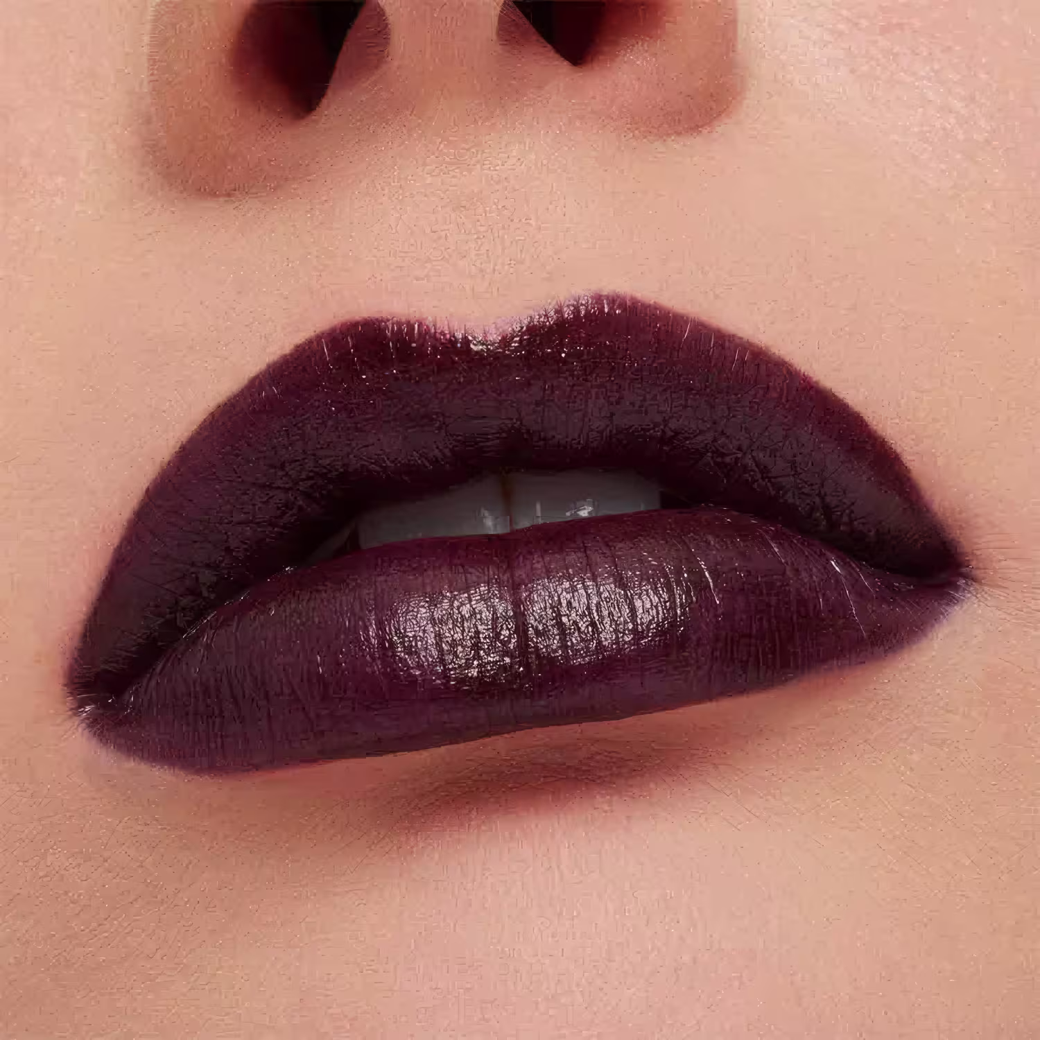 A imagem mostra a boca de uma mulher usando o batom.